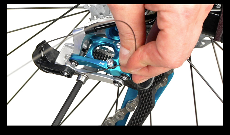 Step 10. With the derailleur still inline with the smallest cog (hardest gear), guide the cable though the correct path and tighten the anchor bolt as you pull the new cable snug