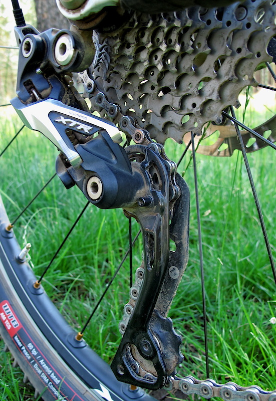 The new 10 speed XTR derailleur uses revised A-arm geometry that results in less cable tension being required for a lighter feel and less sensitivity, as well as reducing the chance of skipping as you pedal over rough terrain. The outer cage is carbon, the inner is aluminum