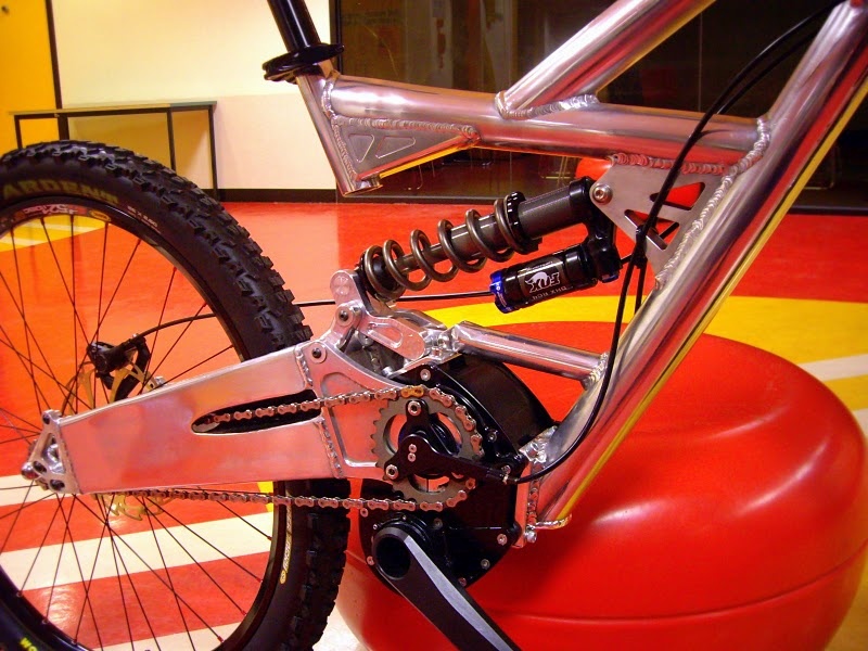 The driveside view of the Jezken makes it look more MotoGP and motocross than mountain bike. Have a look at how the chain passes through the massive swingarm on its way to the rear hub. Although it looks like it would make a fair bit of noise, it is taut and doesn't slap the swingarm at all. The bike is said to be incredibly silent. Pivoting rear dropouts allow the chain to be tensioned by loosening the three bolts and rotating the entire unit back.
