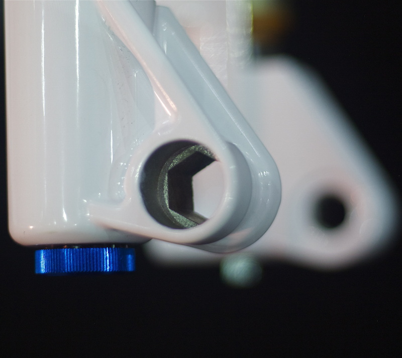 The recessed dropouts on the Marvel are shaped so that the tension adjustment - the gold anodized aluminum dial assembly on the axle - sits mostly inside the lowers, with only the dial itself exposed. The opposite side uses threaded insert for the axle to tighten into that is also replaceable if damaged.