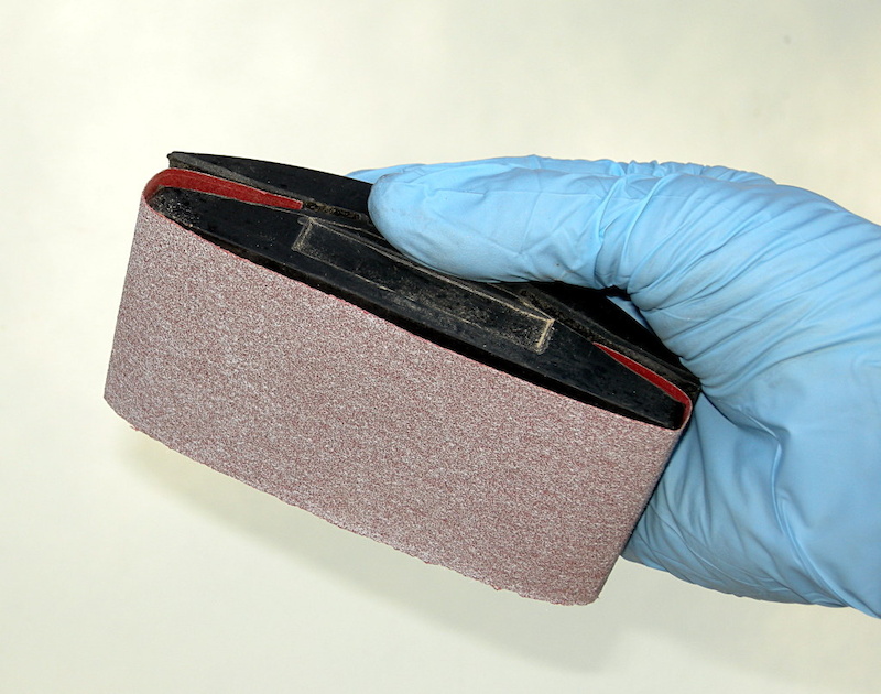 Assemble the abrasive cloth onto the sanding block. Make sure that one edge is virgin so you can work around two-piece rotors with narrow braking tracks.