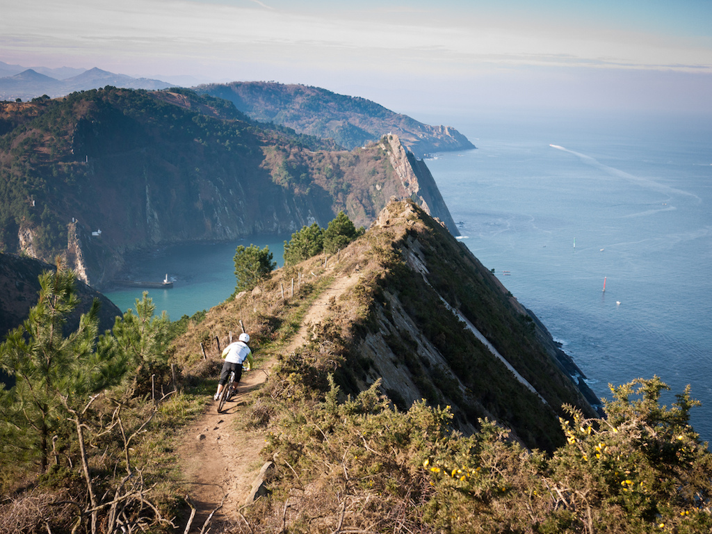 Riding to coastal ridges on the Basque coast. It looks sketchier than it actually feels the trail is fast but you would have to be really really cock up to get over the edge. If you did then it would be a long tumble to a fast drowning 
