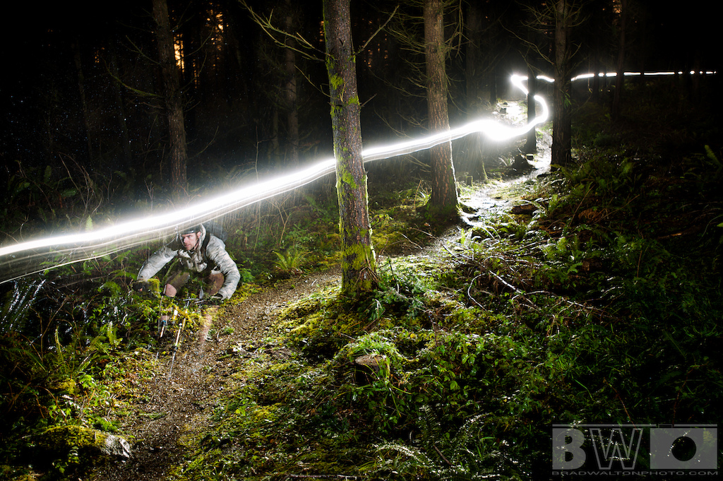 Self-portrait on Kaya in the rain. Long exposure to capture the Niterider headlamp and 2 flashes to freeze the rider. This was done with a remote in hand to fire flashes. Looks ghostly due to the long exposure.