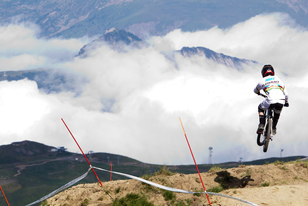 Danny Hart flying over the clouds in the upper part of the giant air downhill