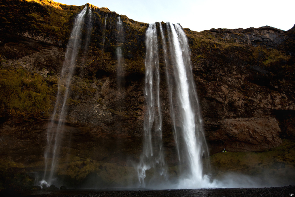 sam pilgrim walks behind the waterfall